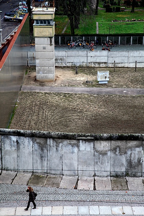 Person Walking by Berlin Wall