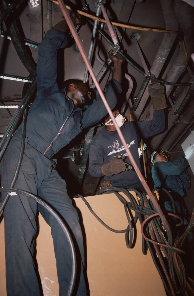 Pipe fitters finishing the engine room of a tuna-fishing boat. Campbell Shipyard. San Diego harbor from the series Fish Story